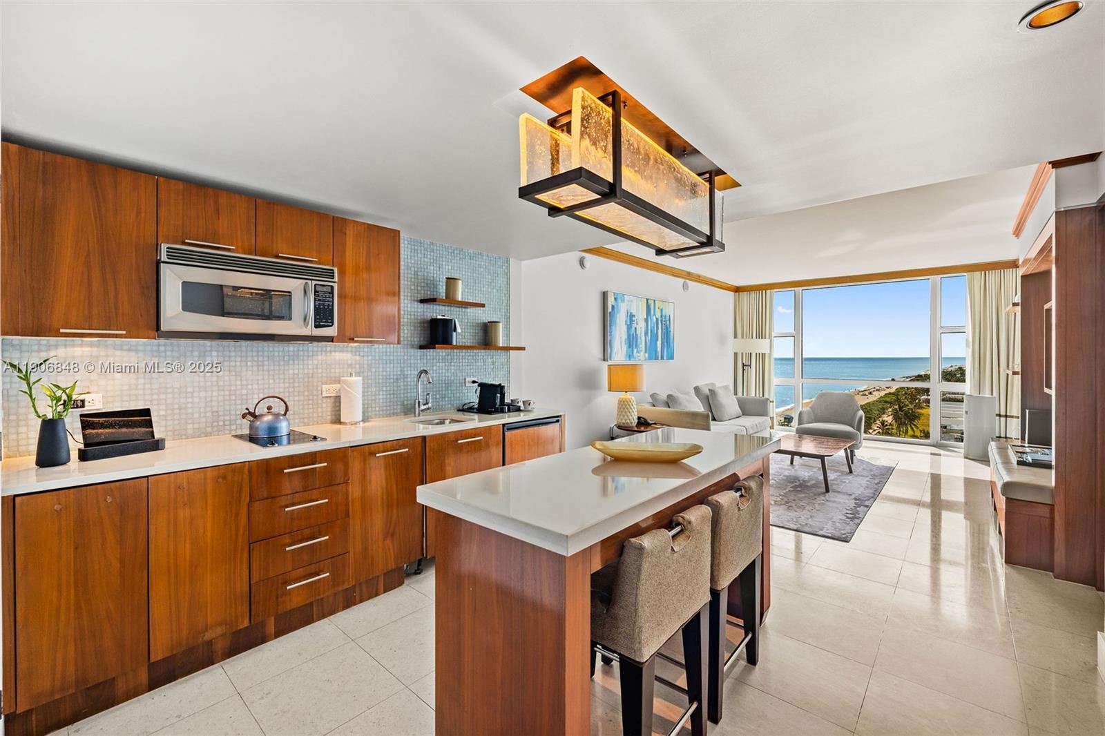 6801 Collins Avenue, Unit 1018 Miami Beach, FL 33141 - Photo 2 of 26 a kitchen with a stove a sink dishwasher and a microwave oven on the kitchen countertops with wooden floor