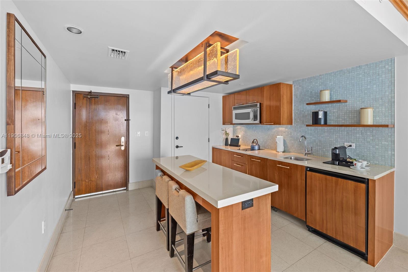 6801 Collins Avenue, Unit 1018 Miami Beach, FL 33141 - Photo 7 of 26 a kitchen with stainless steel appliances granite countertop a sink and a refrigerator