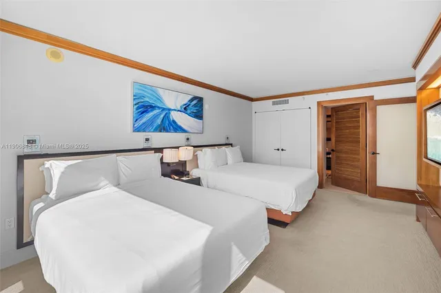 a bedroom with a large bed and a chandelier