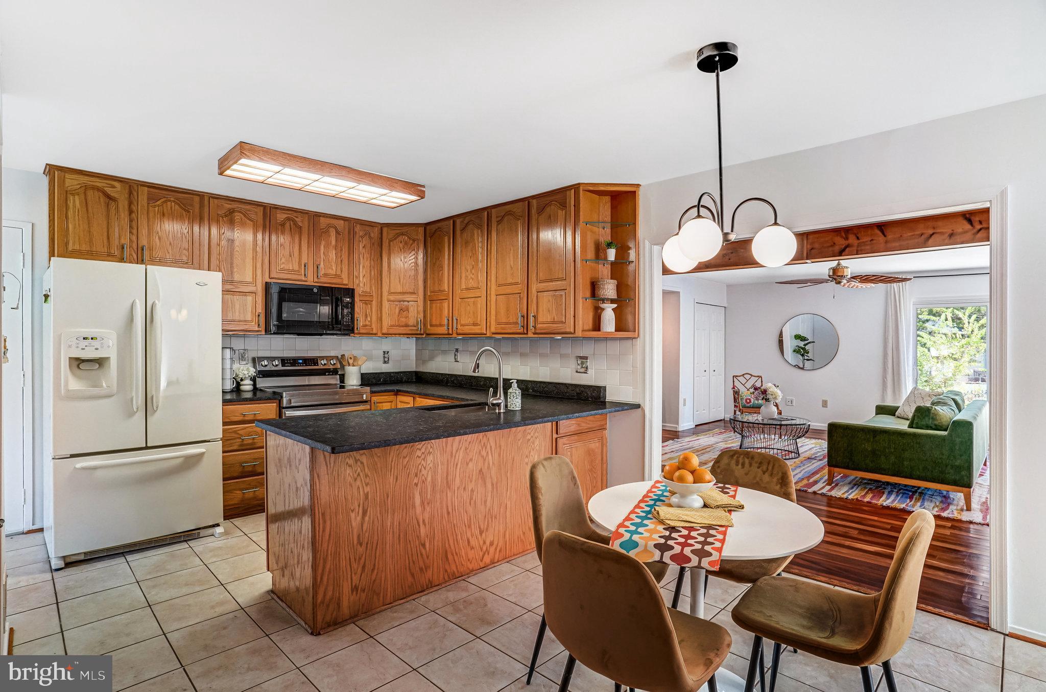 7709 Brandon Way Manassas, VA 20109 - Photo 11 of 40 a kitchen with stainless steel appliances granite countertop a stove a refrigerator a kitchen island a dining table and chairs
