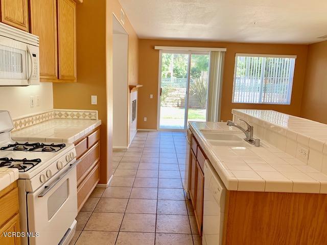 2153 Ribera Drive Oxnard, CA 93030 - Photo 7 of 34 a kitchen with a sink stove and cabinets