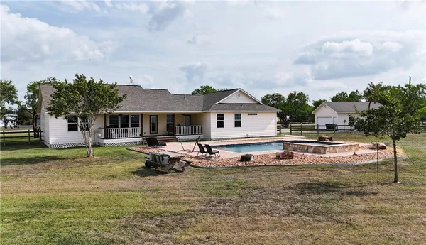 a view of a house with backyard and sitting area