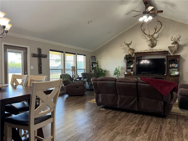 a living room with furniture a flat screen tv and wooden floor