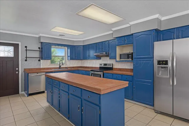 a kitchen with stainless steel appliances granite countertop a refrigerator and a sink