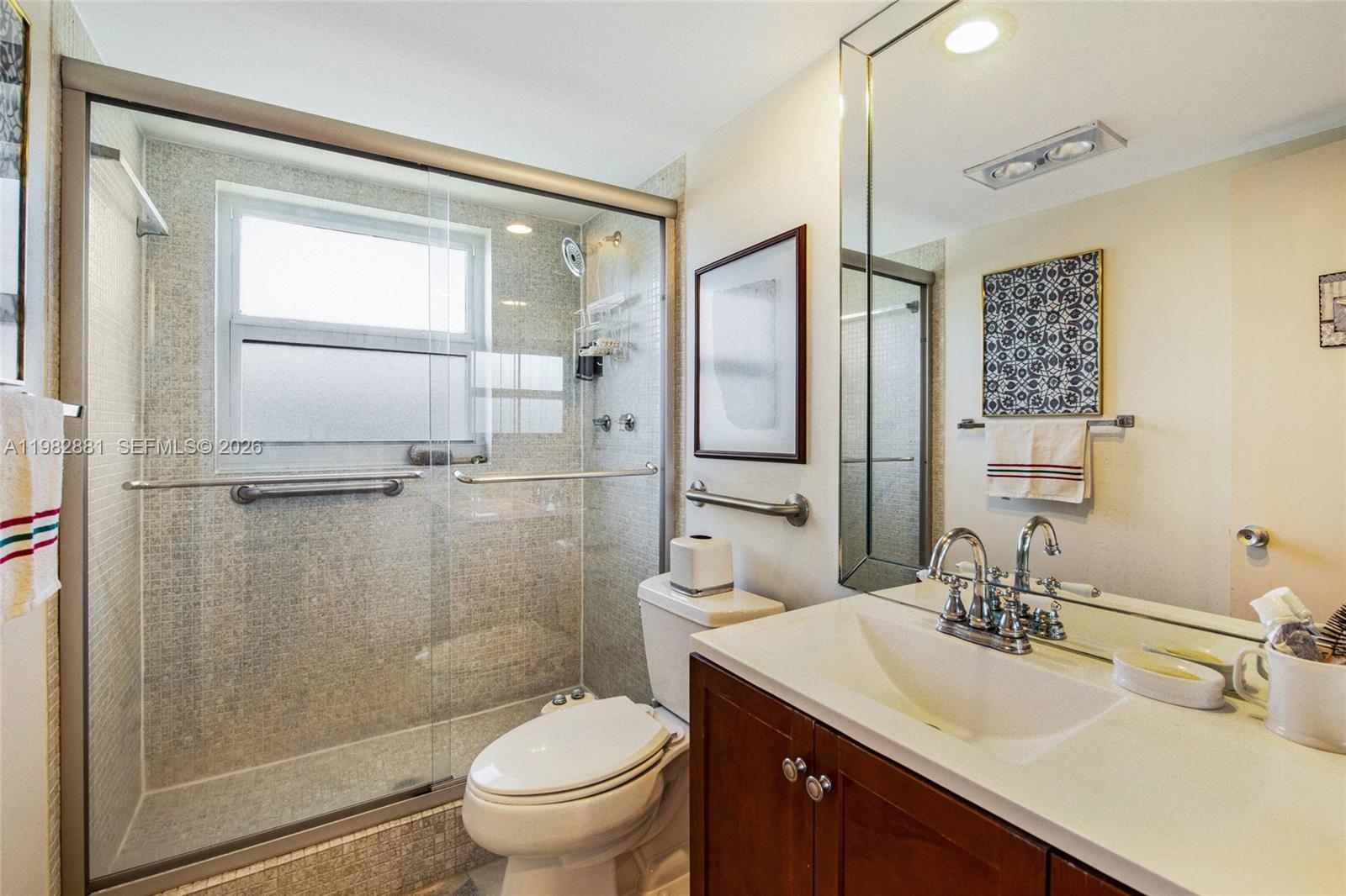 3050 Northeast 48th Court, Unit 401 Lighthouse Point, FL 33064 - Photo 15 of 35 a bathroom with a sink toilet and shower