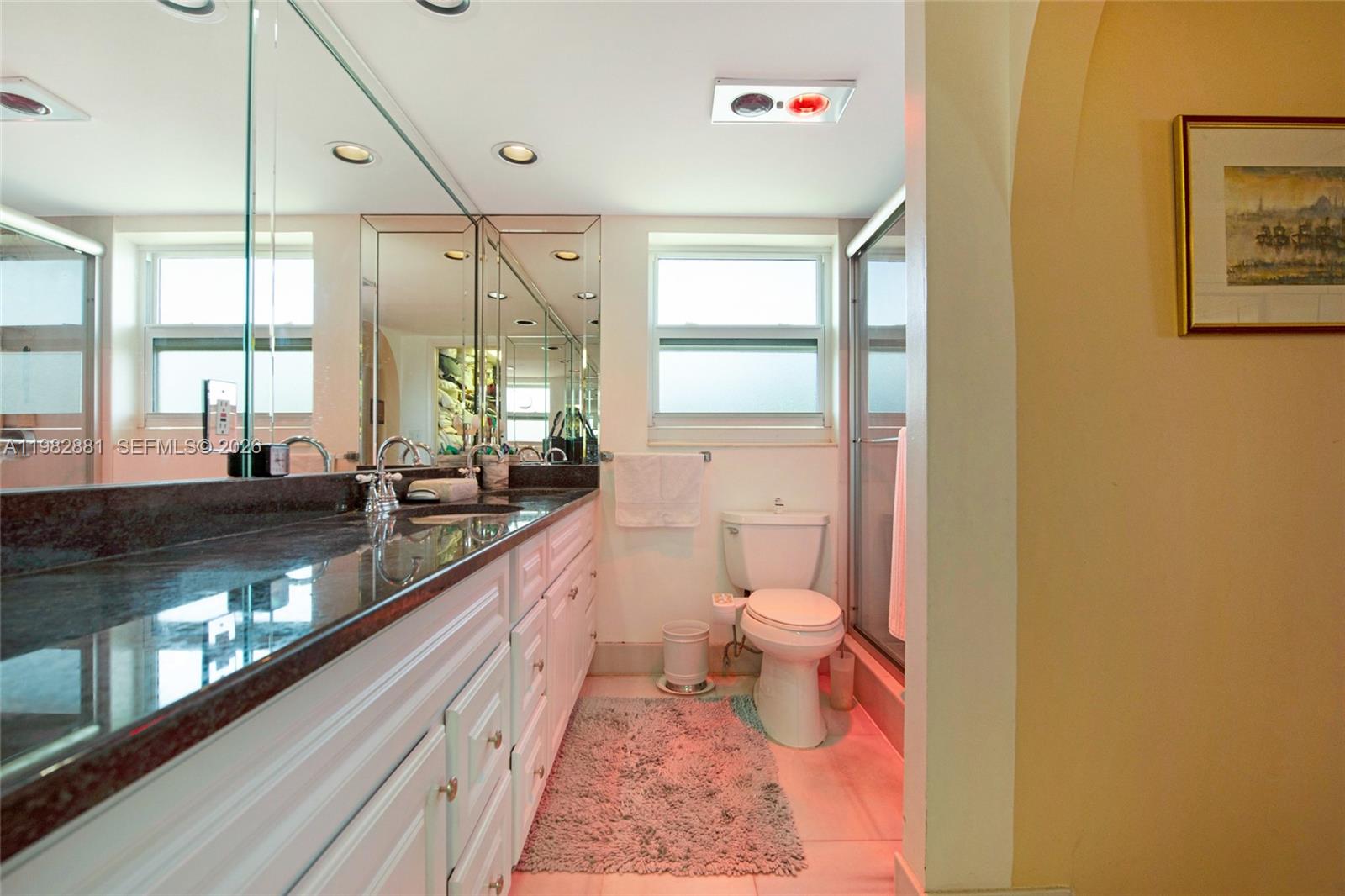 3050 Northeast 48th Court, Unit 401 Lighthouse Point, FL 33064 - Photo 18 of 35 a bathroom with a sink mirror vanity and a toilet
