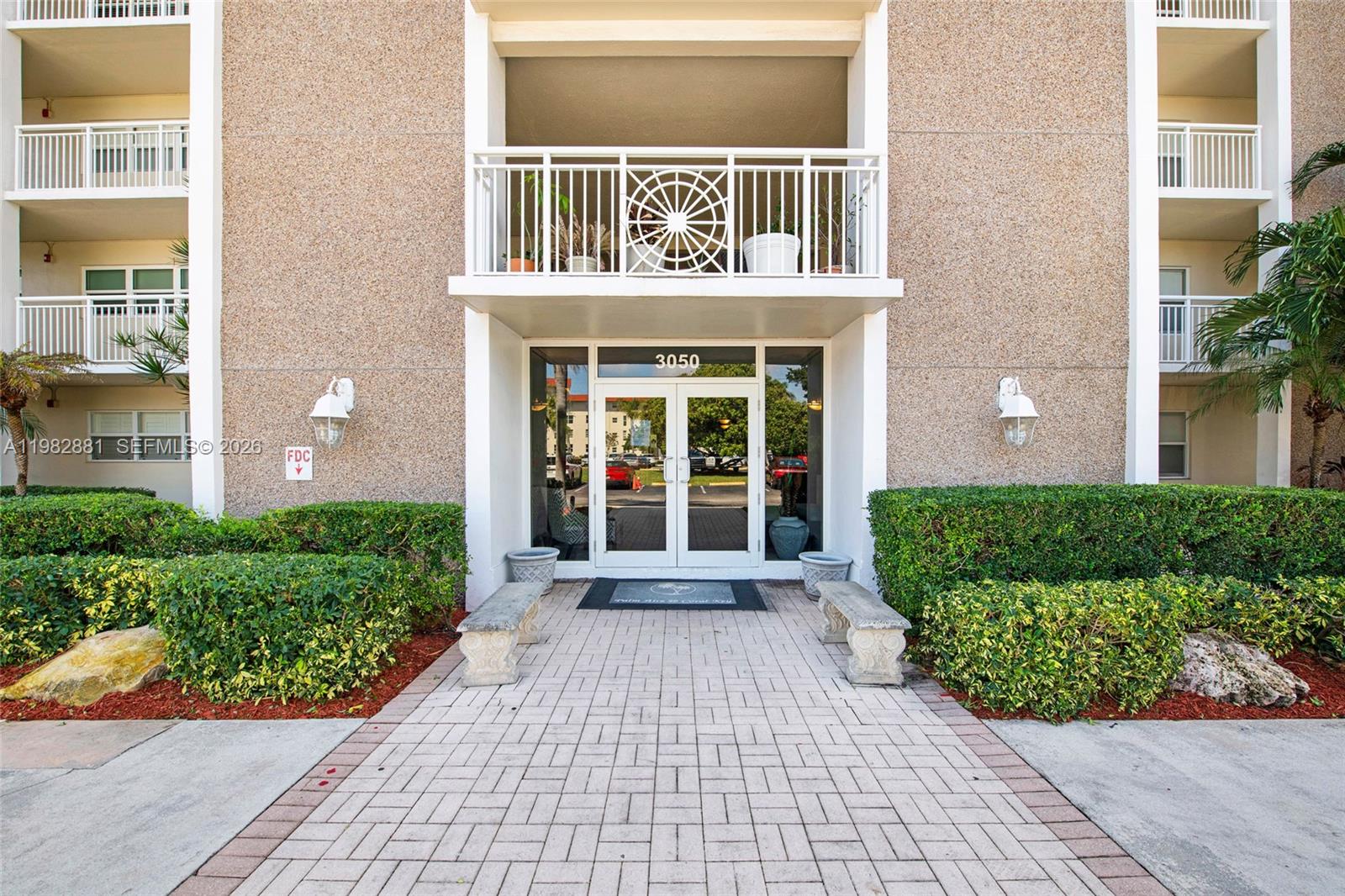 3050 Northeast 48th Court, Unit 401 Lighthouse Point, FL 33064 - Photo 24 of 35 a front view of a house with a garden