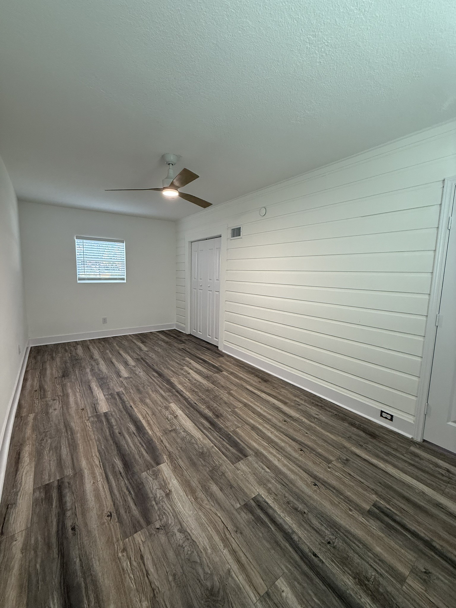 705 Stanford Street, Unit A Houston, TX 77019 - Photo 12 of 16 an empty room with wooden floor and windows