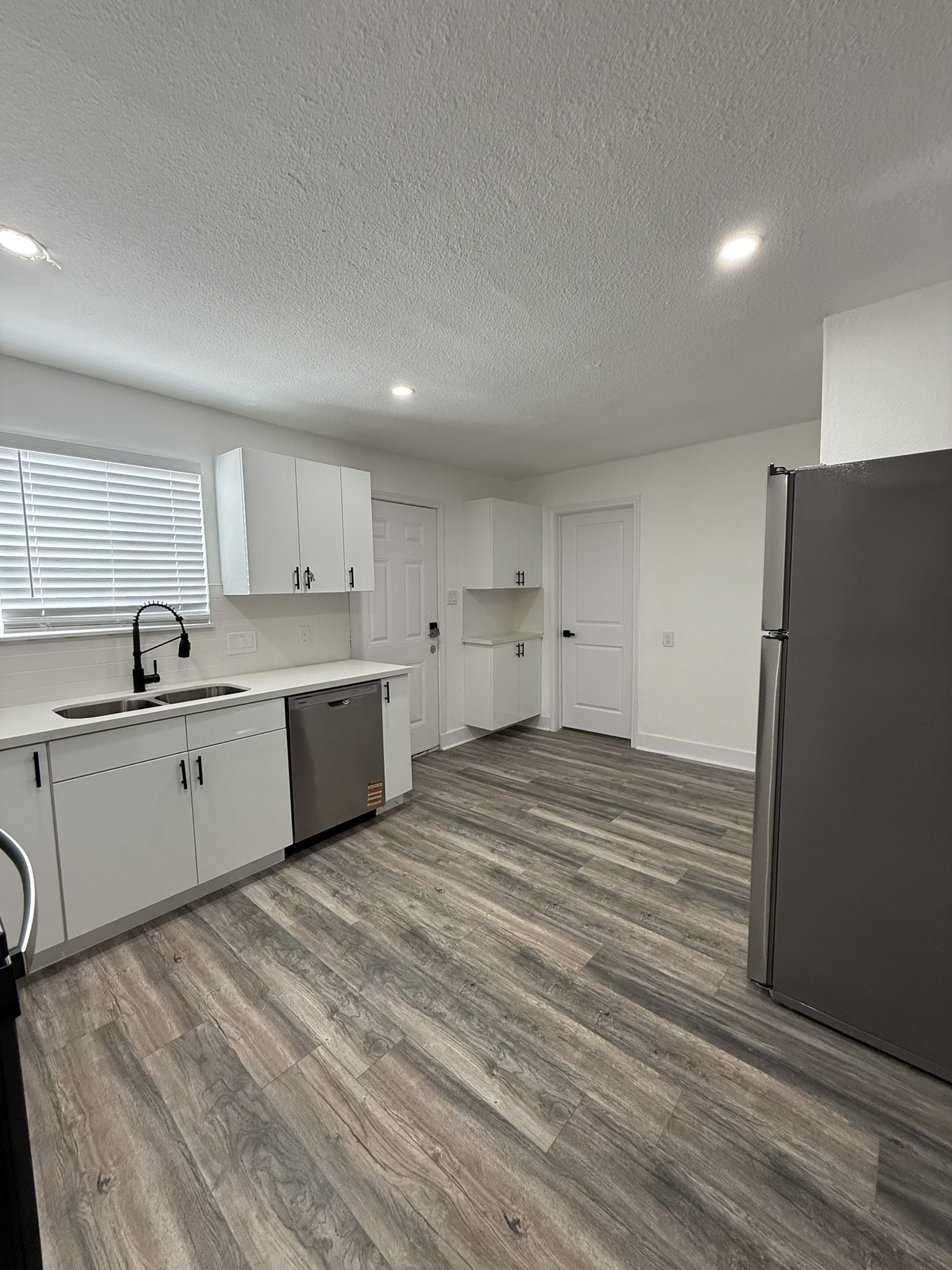 705 Stanford Street, Unit A Houston, TX 77019 - Photo 5 of 16 a large kitchen with a stove a refrigerator a sink dishwasher with a large mirror and cabinets