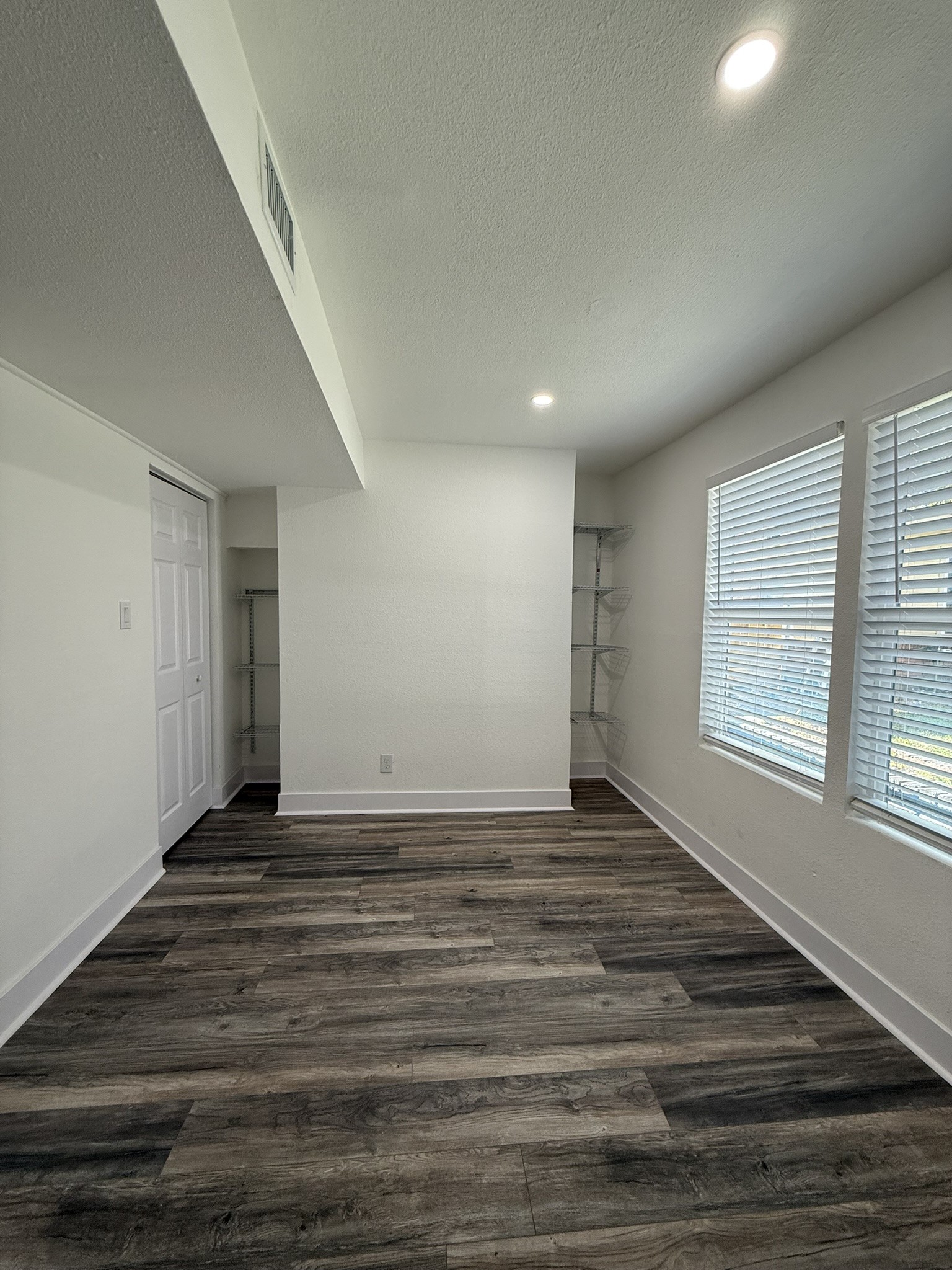 705 Stanford Street, Unit A Houston, TX 77019 - Photo 9 of 16 a view of an empty room with wooden floor and a window