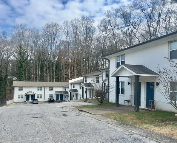 a view of a house with large trees and a barn