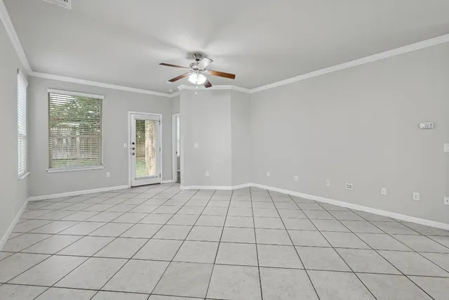 a view of an empty room and window chandelier fan