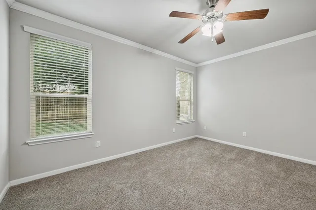an empty room with windows and fan