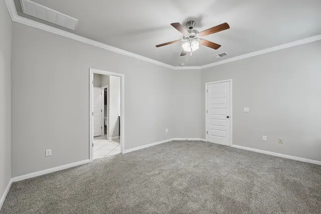 an empty room with closet and ceiling fan