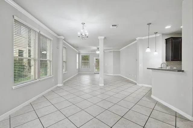 a view of an empty room and a kitchen
