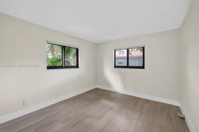 a view of a room with wooden floor and window