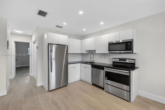 a kitchen with stainless steel appliances granite countertop a stove a refrigerator and a microwave