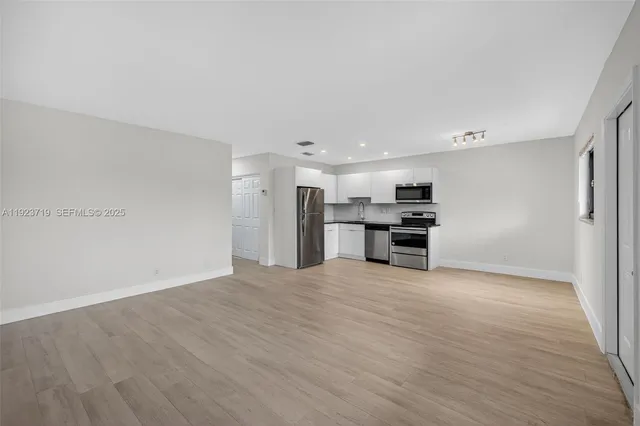 a view of a kitchen with a sink and a refrigerator