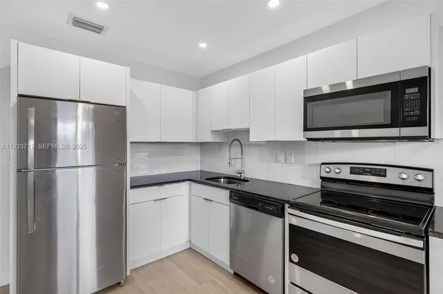 a kitchen with stainless steel appliances a stove a microwave and a refrigerator