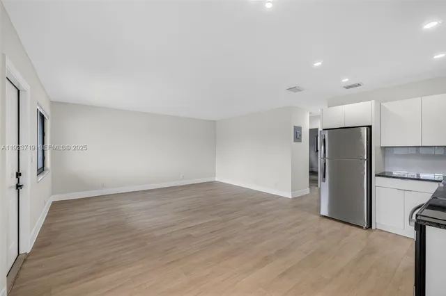 a view of an empty room with a kitchen