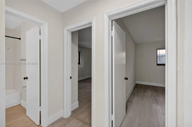 a view of a hallway with wooden floor