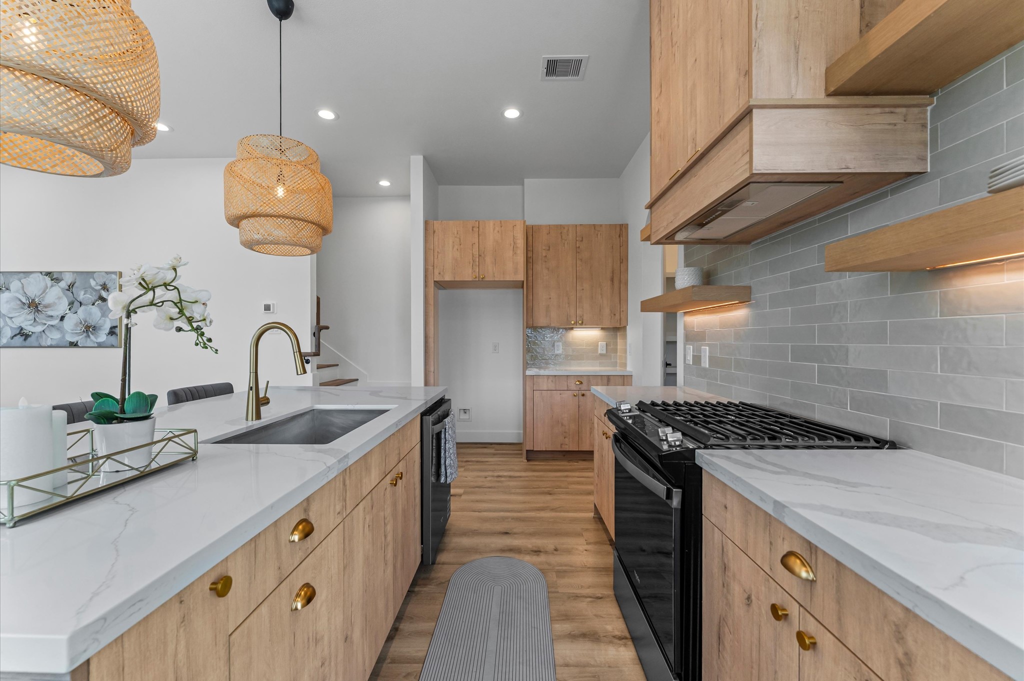 1122 West 17th Street, Unit D Houston, TX 77008 - Photo 15 of 37 a kitchen with kitchen island stainless steel appliances a sink a stove and a wooden floors