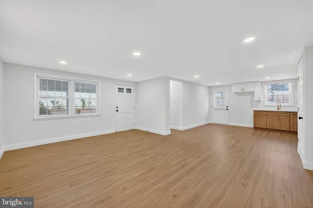 a view of empty room with wooden floor and window