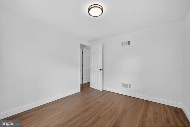 a view of a room with wooden floor and white walls