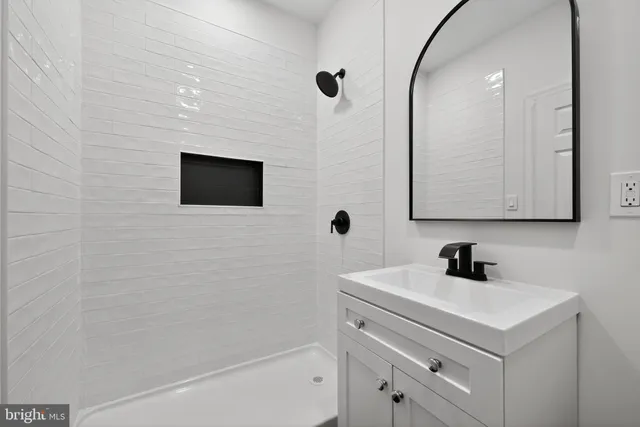 a bathroom with a sink a mirror and a shower