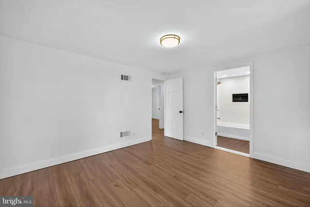 a view of empty room with wooden floor