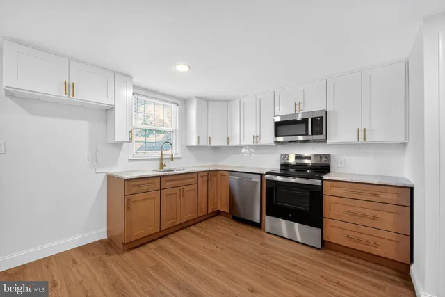 a kitchen with sink a microwave and cabinets