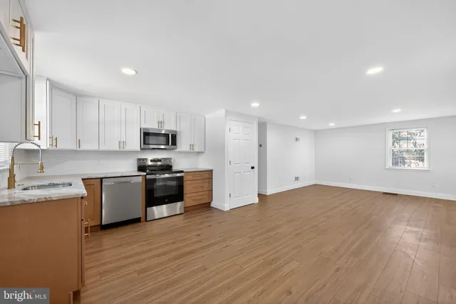 a large kitchen with stainless steel appliances granite countertop a stove a sink and a refrigerator