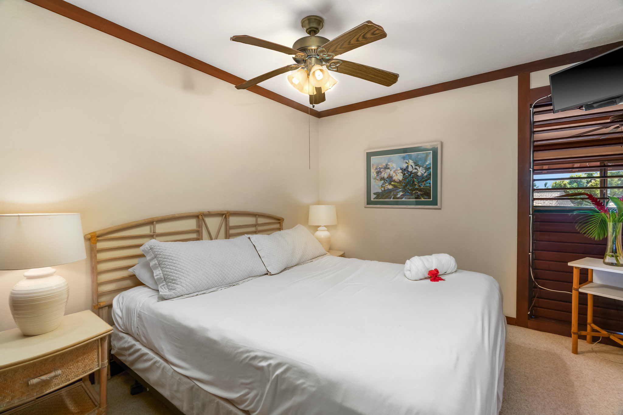 2253 Poipu Road, Unit 109 Koloa, HI 96756 - Photo 2 of 12 a bedroom with a bed and a chandelier fan