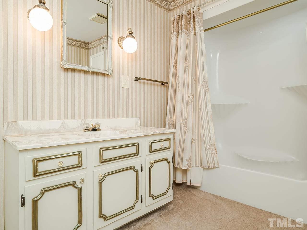 3308 Apache Drive Raleigh, NC 27609 - Photo 21 of 29 a bathroom with a sink a mirror and a bathtub