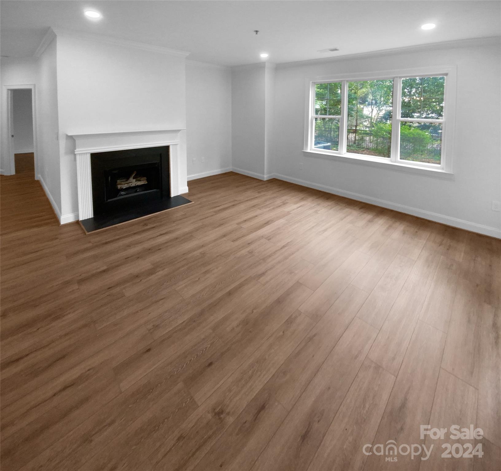 5601 Fairview Road, Unit 5 Charlotte, NC 28209 - Photo 6 of 16 an empty room with wooden floor fireplace and windows
