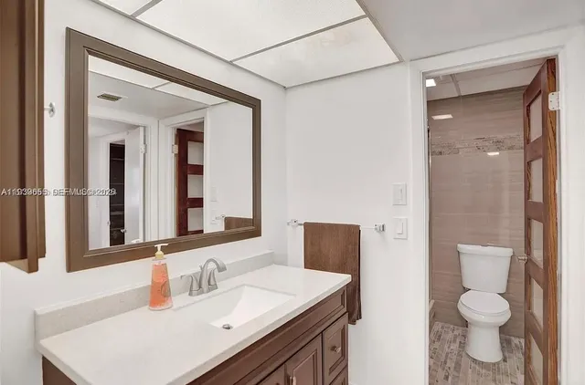 a bathroom with a sink toilet vanity and shower