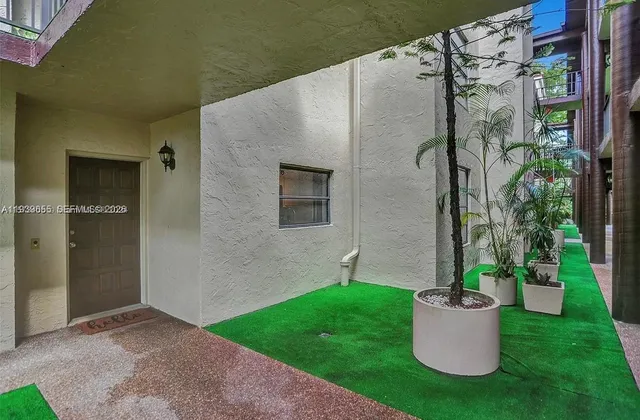 a view of a small house with a potted plant and a yard
