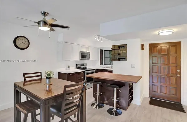 a view of a kitchen area with furniture and stainless steel appliances