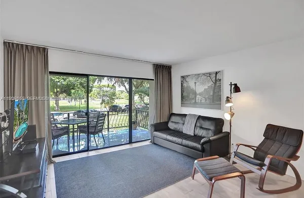 a living room with furniture and a floor to ceiling window