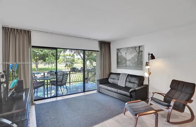 a living room with furniture and a floor to ceiling window