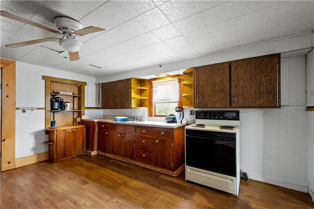11 Madison Street Cokeburg, PA 15324 - Photo 16 of 35 a kitchen with stainless steel appliances granite countertop a stove cabinets and wooden floor