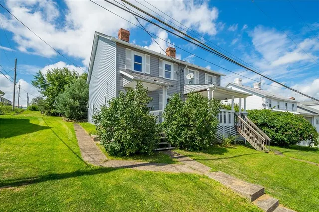 a view of a big house with a big yard and potted plants