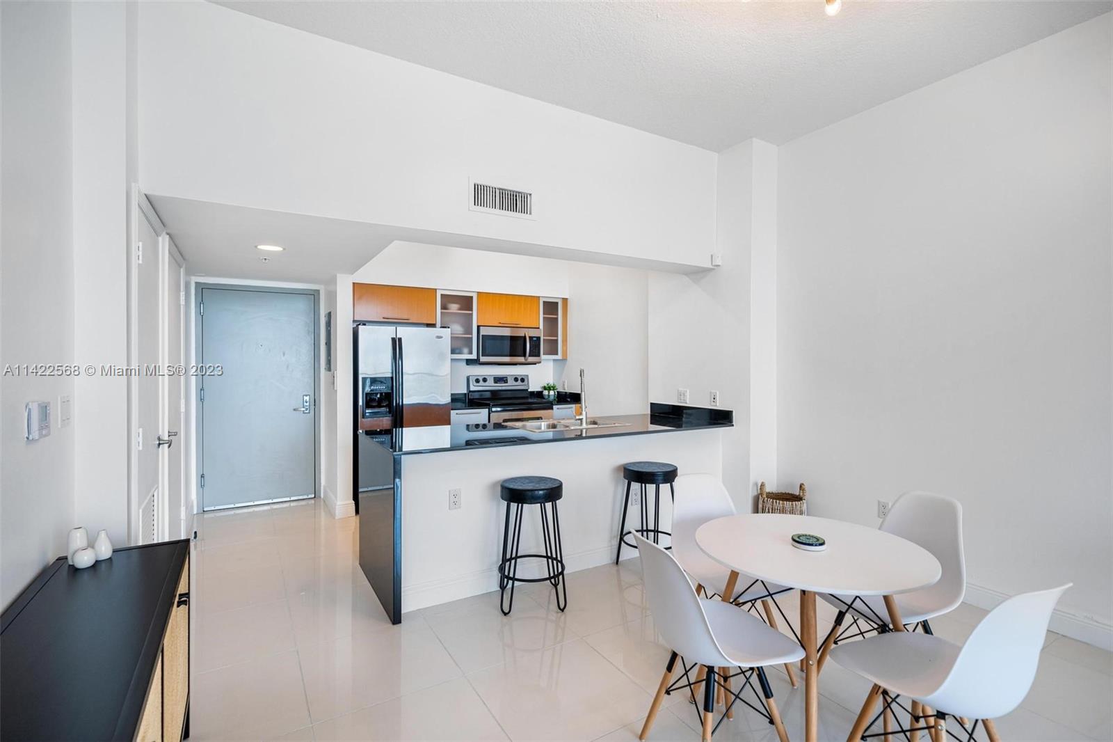 Edgewater Miami, FL 33132 - Photo 9 of 23 a kitchen with stainless steel appliances a dining table chairs and a refrigerator
