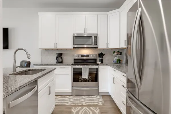a kitchen with stainless steel appliances granite countertop a stove a microwave and cabinets