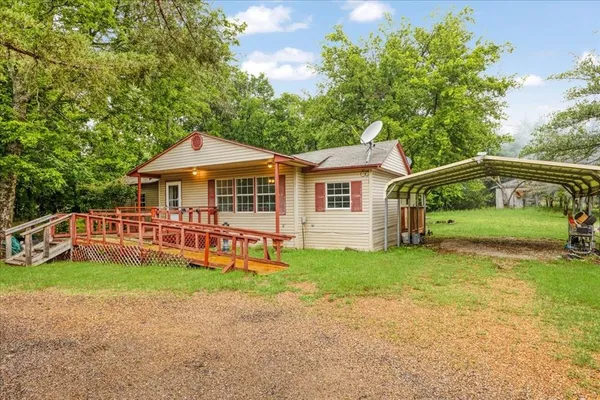 a view of a house with a yard and deck