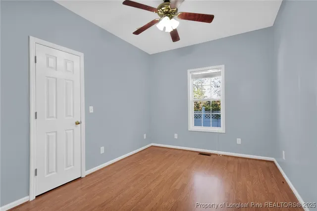 a view of an empty room with wooden floor