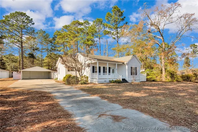 a front view of a house with a yard and trees
