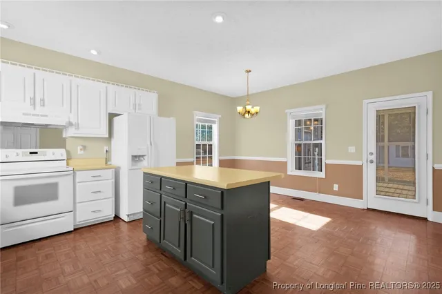 a kitchen with white cabinets and sink