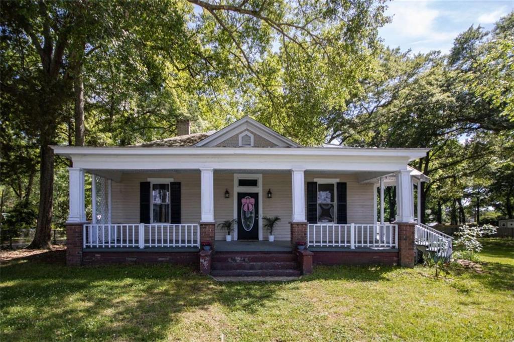 285 East Main Street Forsyth, GA 31029 - Photo 1 of 27 a view of a house with a yard and a porch with a large tree