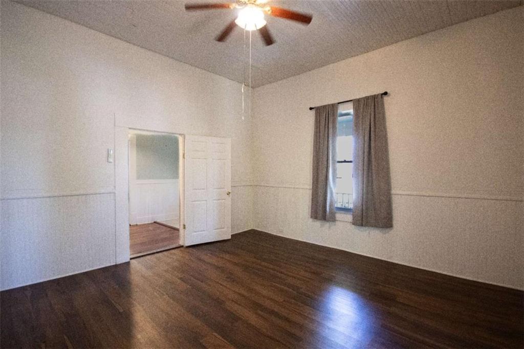 285 East Main Street Forsyth, GA 31029 - Photo 19 of 27 an empty room with wooden floor chandelier fan and windows